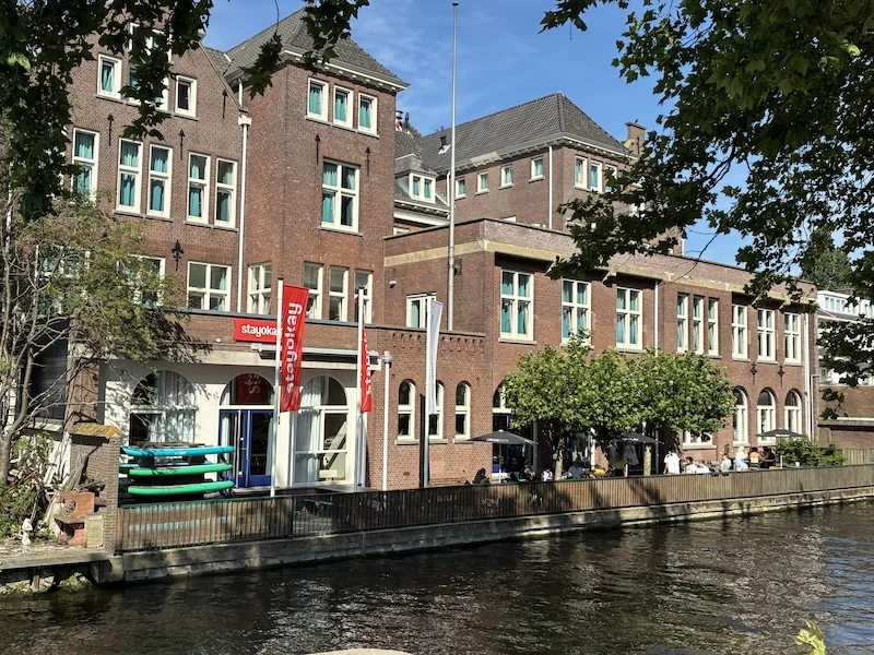 Stayokay Den Haag buitenkant aan het water Buitenkant van Stayokay Den Haag aan het water, met een terras langs de gevel
