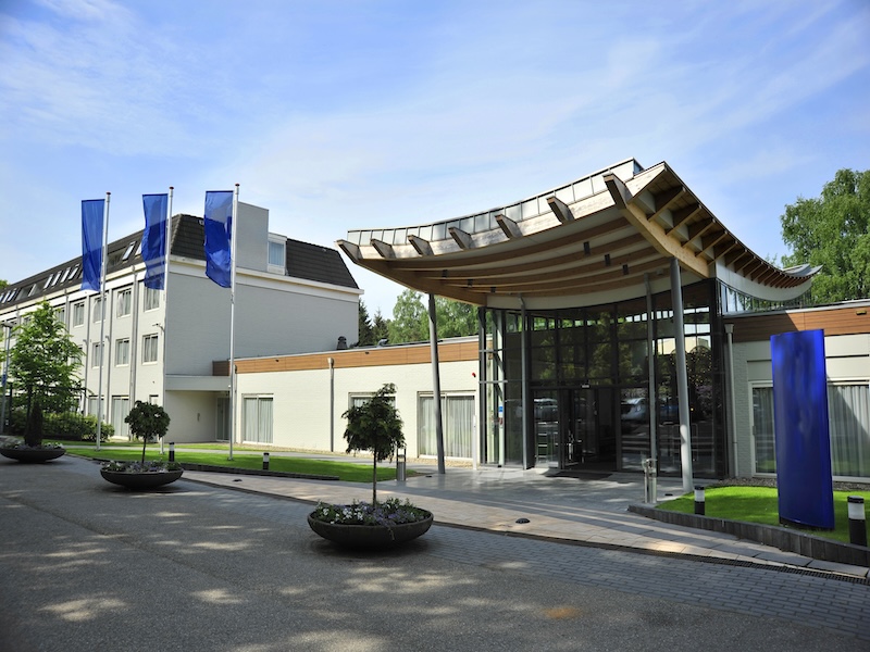 Buitenzijde van Fletcher Hotel-Restaurant Doorwerth-Arnhem, omgeven door groen tussen Arnhem en de Veluwe.